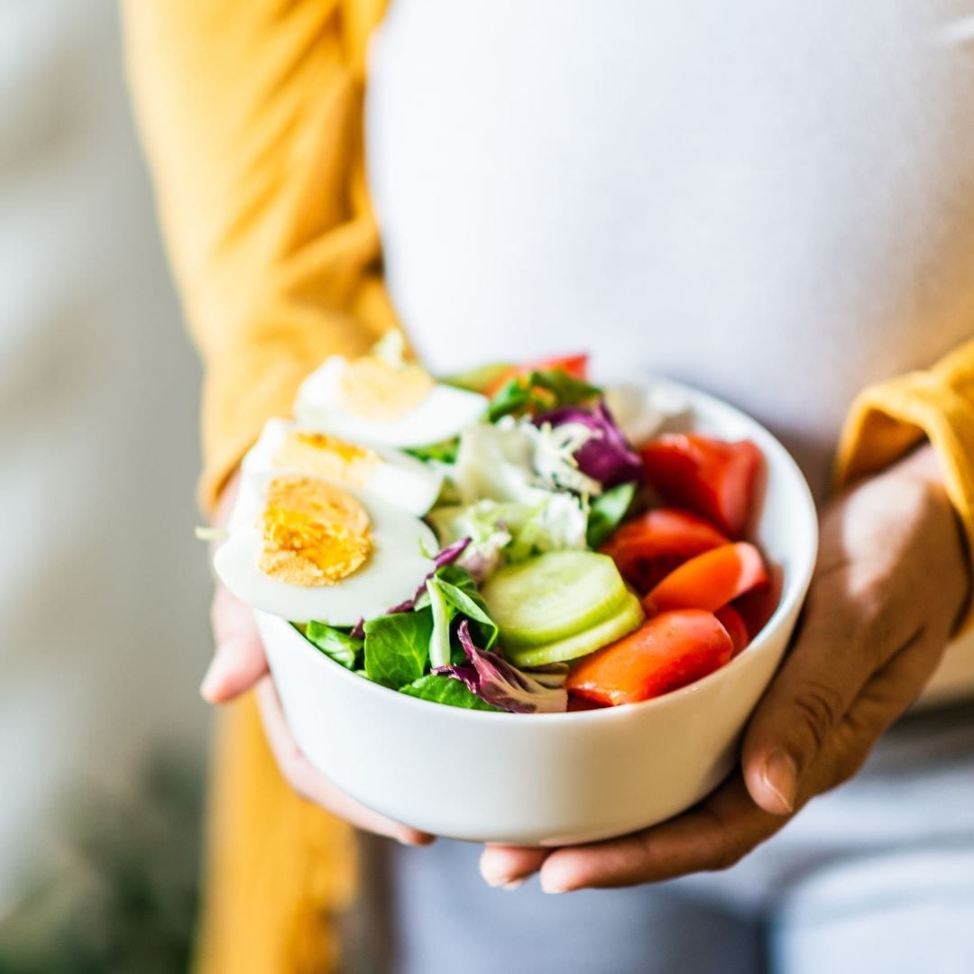 A bowl of salad held in both hands